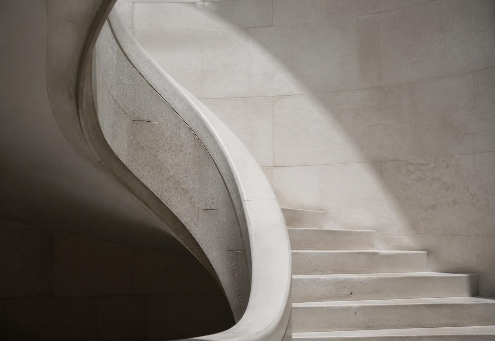 Curved limestone staircase in soft daylight
